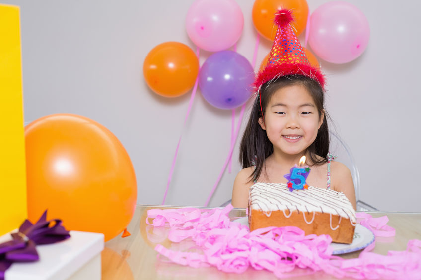 Close-up portrait of a cheerful little girl at her birthday party