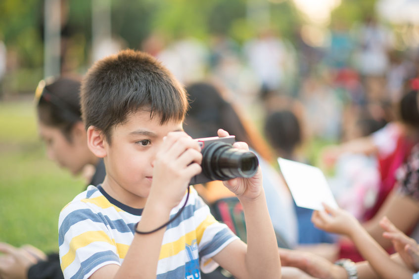 Little  boy look at digital camera after shoot image on travel